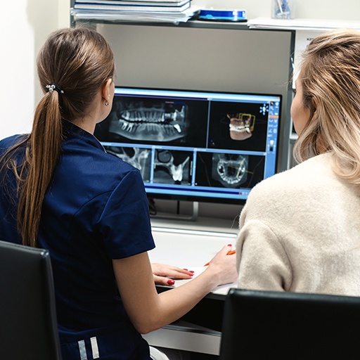 Two dental team members reviewing digital x-rays