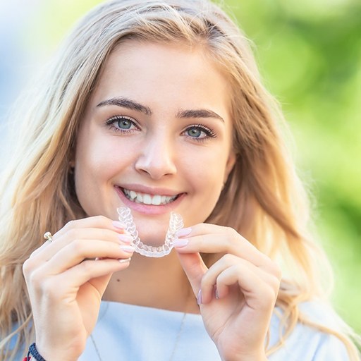 patient holding Invisalign in Winfield 