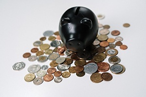 Black piggy bank and coins on white background