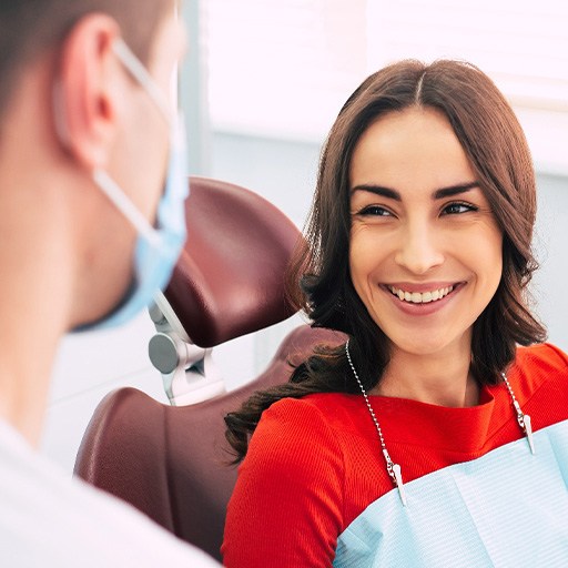 Woman smiling at dentist while sitting in treatment chair