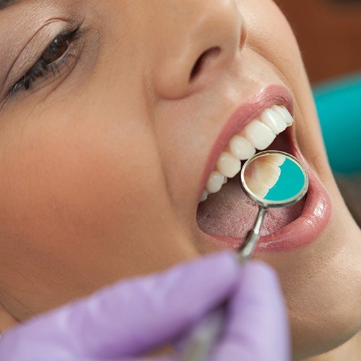 Dentist examining patient's smile after metal free dental restoration