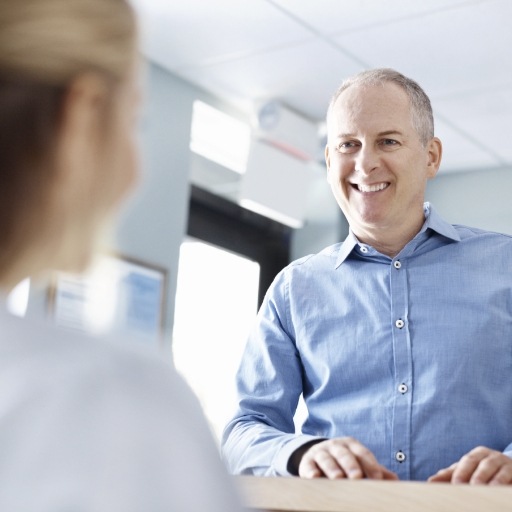 Dental patient discussing the cost of dental implant tooth replacement with team member