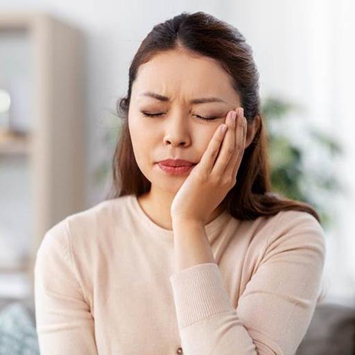 Woman with a toothache in Winfield holding her face