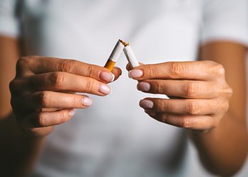 a person breaking a cigarette in half