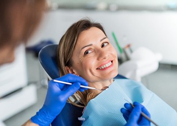 a patient smiling while visiting her dentist