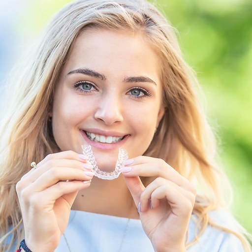 patient holding Invisalign in Winfield