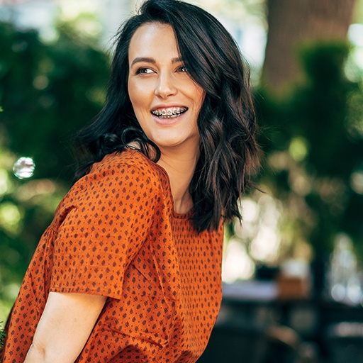 Smiling woman with traditional bracs orthodontics