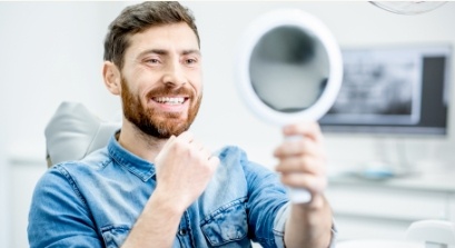 Man looking at his healthy smile after preventive dentistry visit