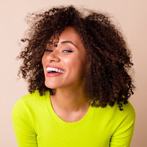 a woman showing off her brand-new smile with veneers
