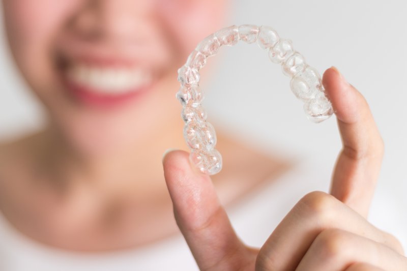 patient holding an Invisalign aligner