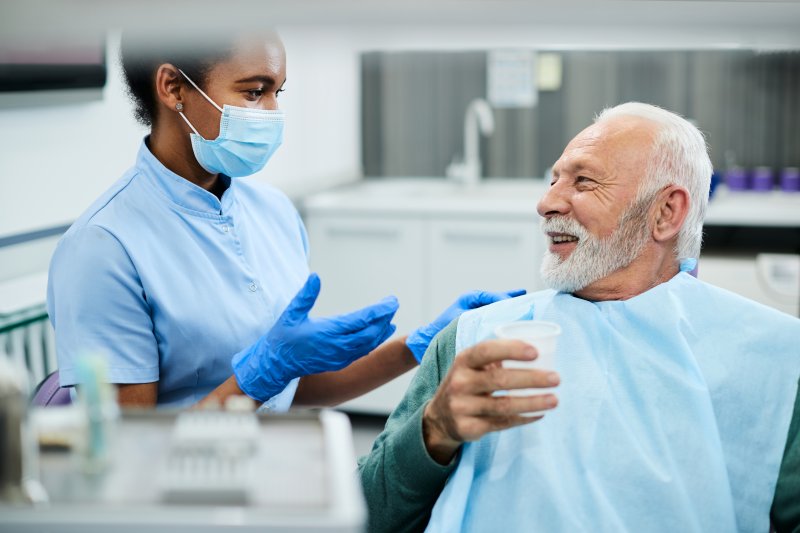 dentist talking about dental implant success with patient
