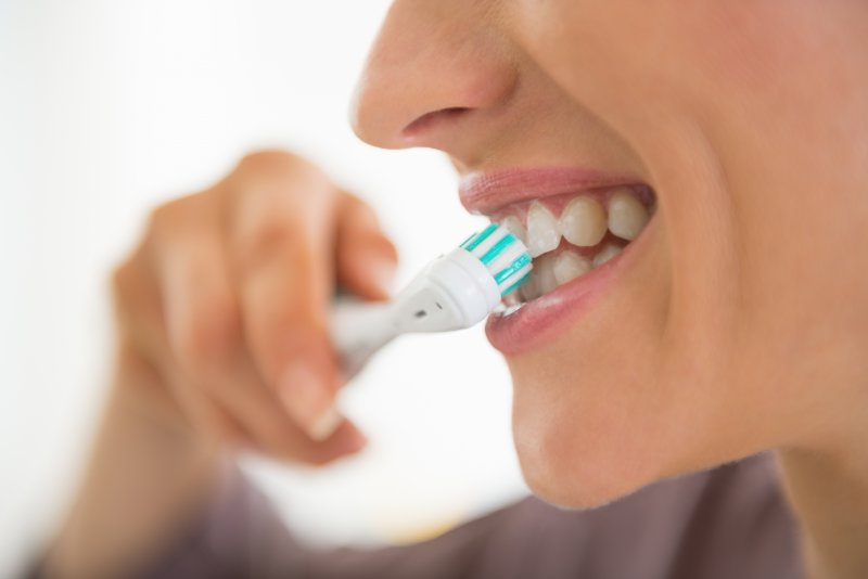 A young woman with a beautiful smile brushing her teeth